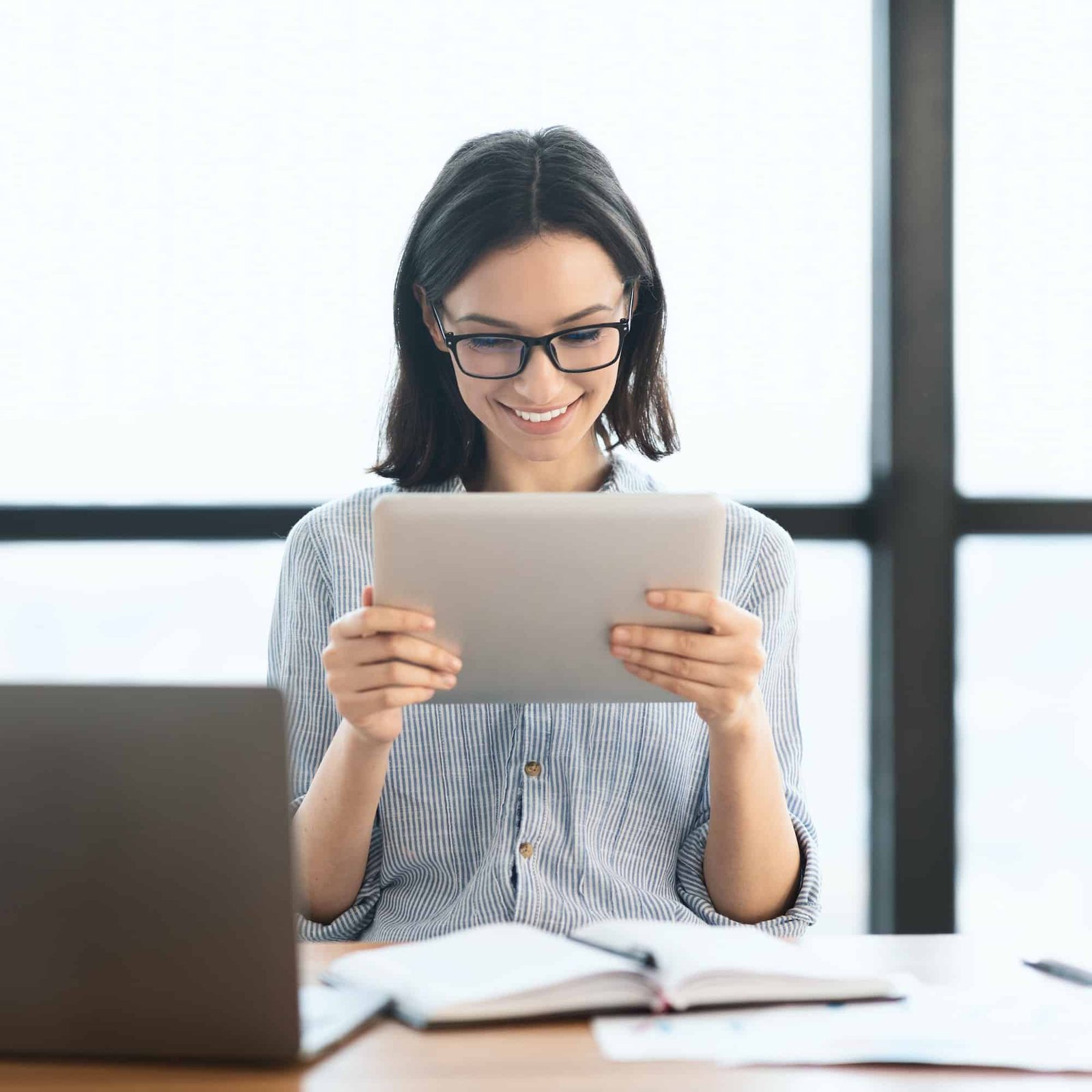 young-girl-holding-tablet-and-using-laptop-at-office.jpg young-girl-holding-tablet-and-using-laptop-at-office.jpg